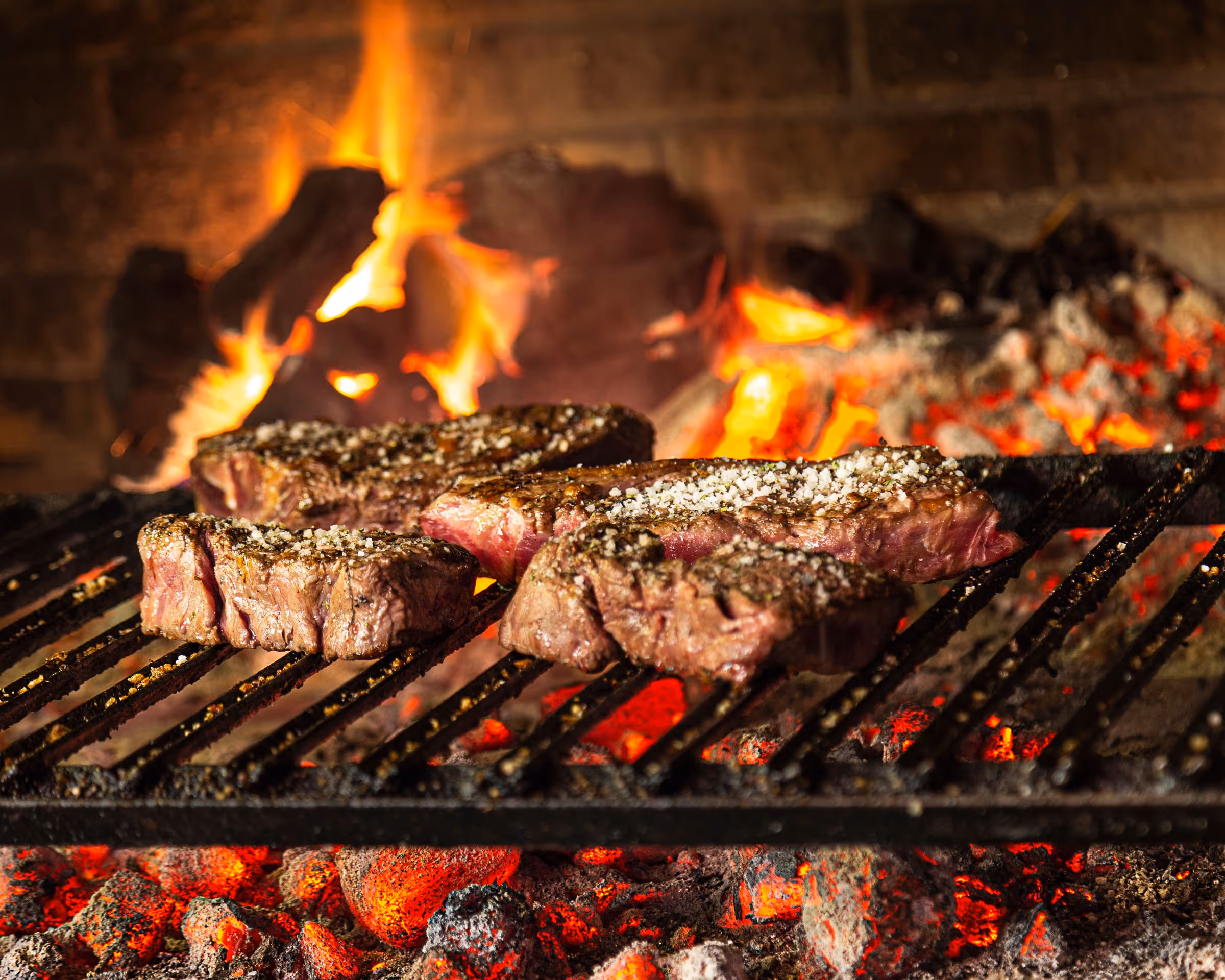 Txuletas de vaca vieja sobre la parrilla de carbón, con la brasa al rojo vivo